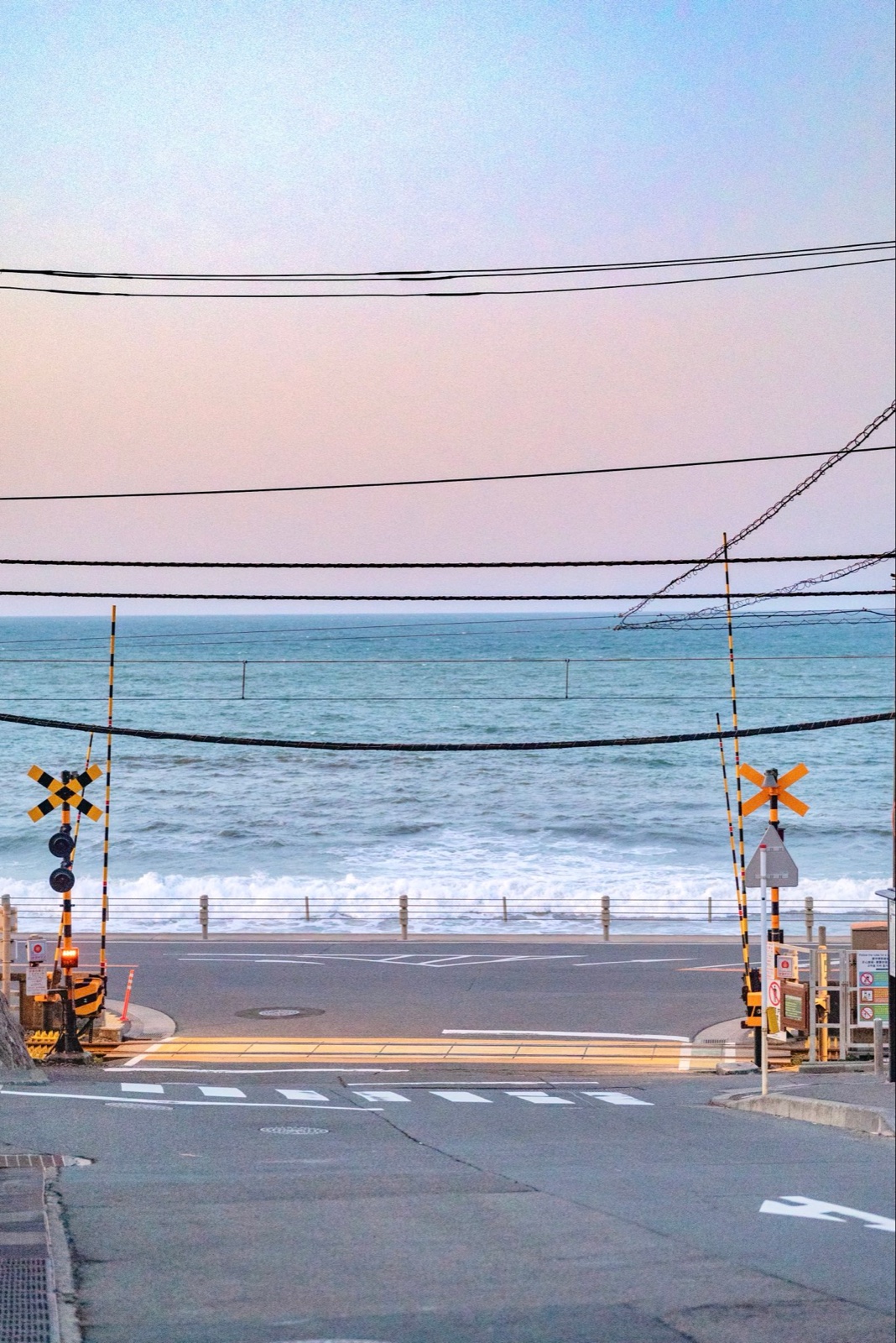 海边铁路道口，马路另一侧是大海